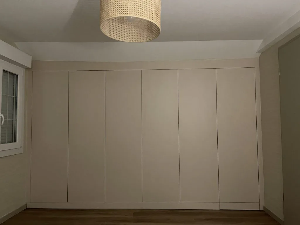 Façade de placards beiges du dressing avec portes toute hauteur