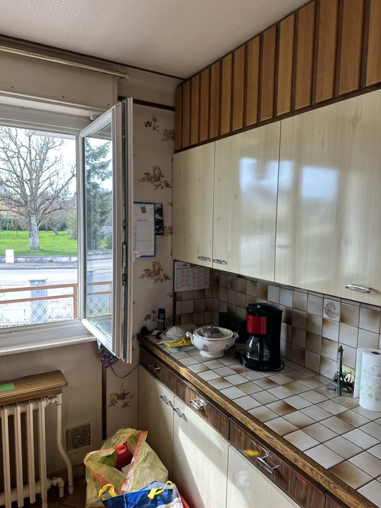 Cuisine avant rénovation avec meubles blancs anciens et plan de travail carrelé