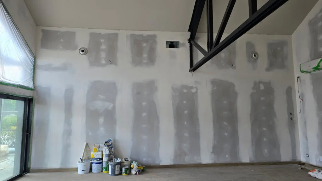 Cloison sous poutre métallique noire pendant les travaux d’aménagement du salon de thé
