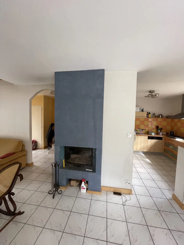 Cheminée avant rénovation avec habillage bleu et sol carrelé