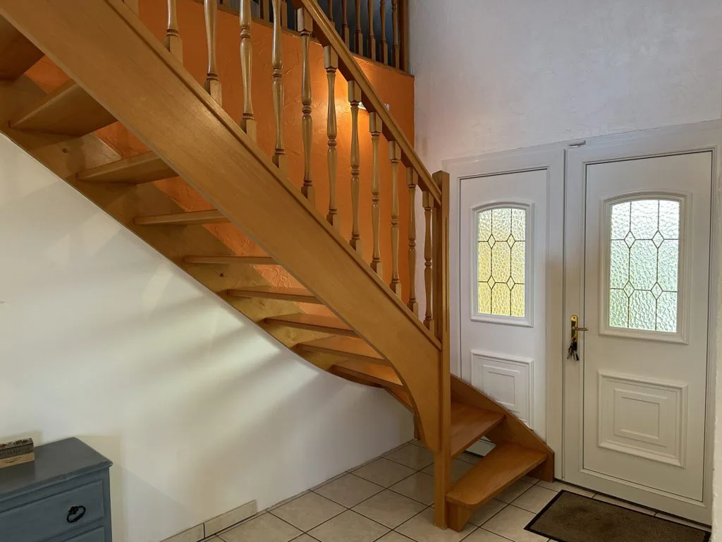 Escalier en bois et double porte d’entrée vitrée avant rénovation