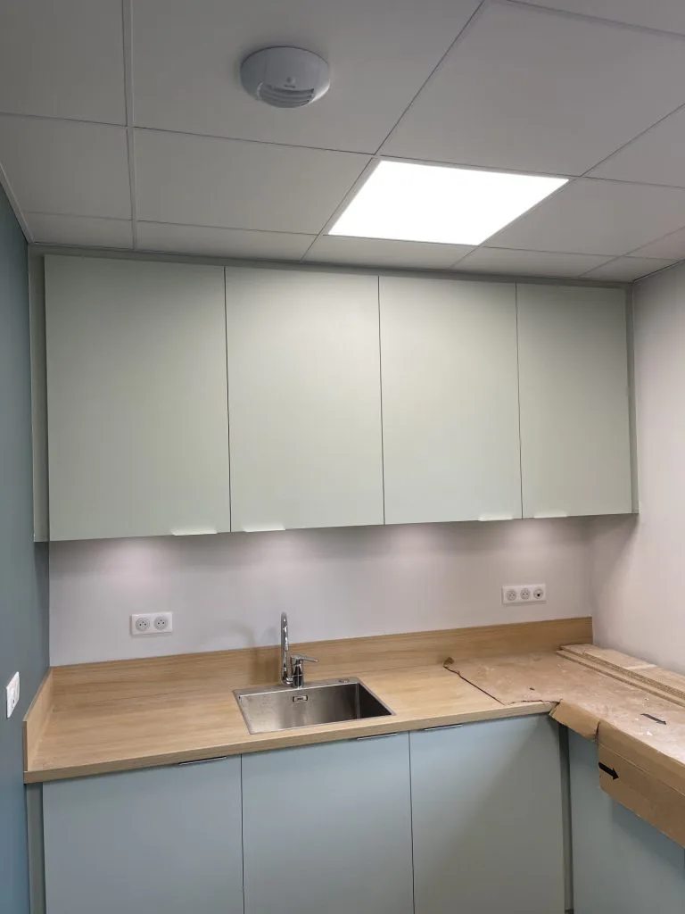 Évier et meubles gris de la kitchenette sur un plan de travail en bois