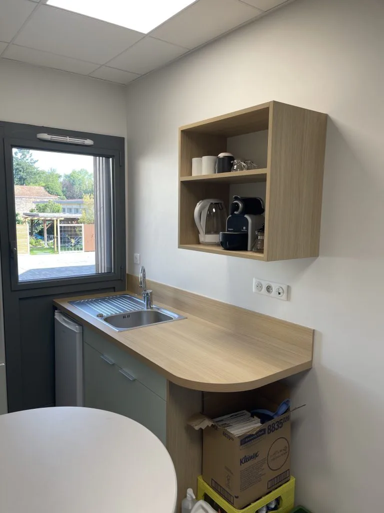 Coin café de la kitchenette avec fenêtre, rangement ouvert et plan de travail en bois