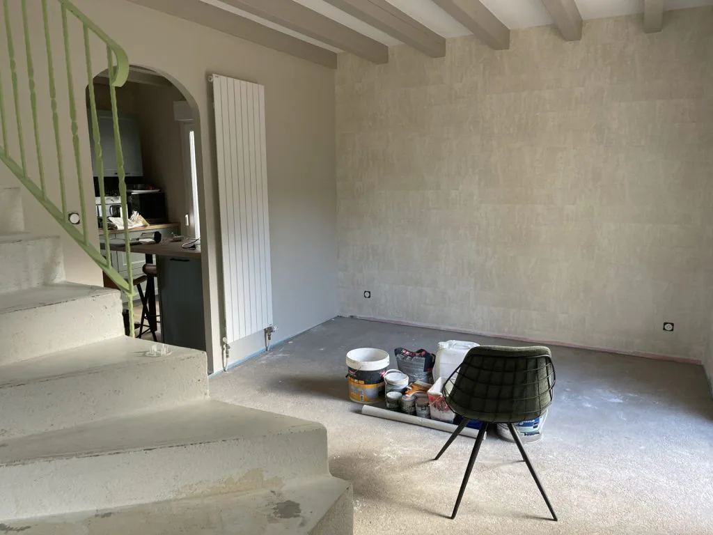 Vue rapprochée du salon en travaux au pied de l’escalier
