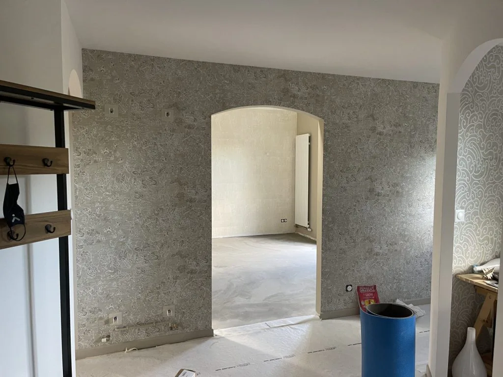 Passage entre deux pièces en travaux avec revêtement mural texturé