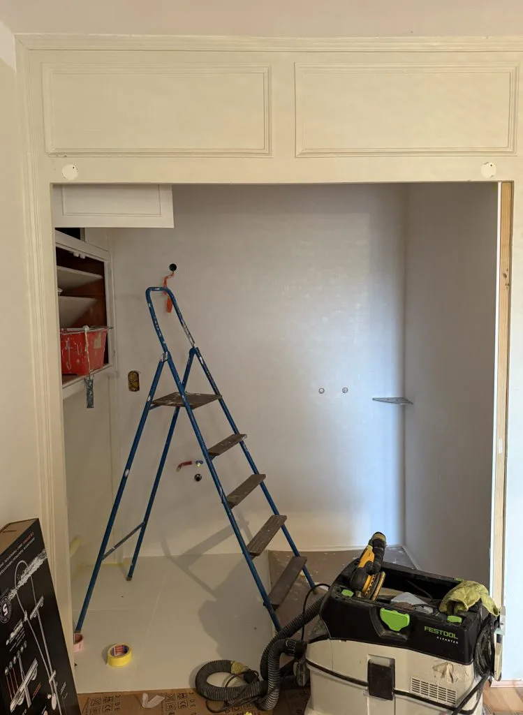 Espace sous placards pendant les travaux, avec escabeau et matériel de chantier