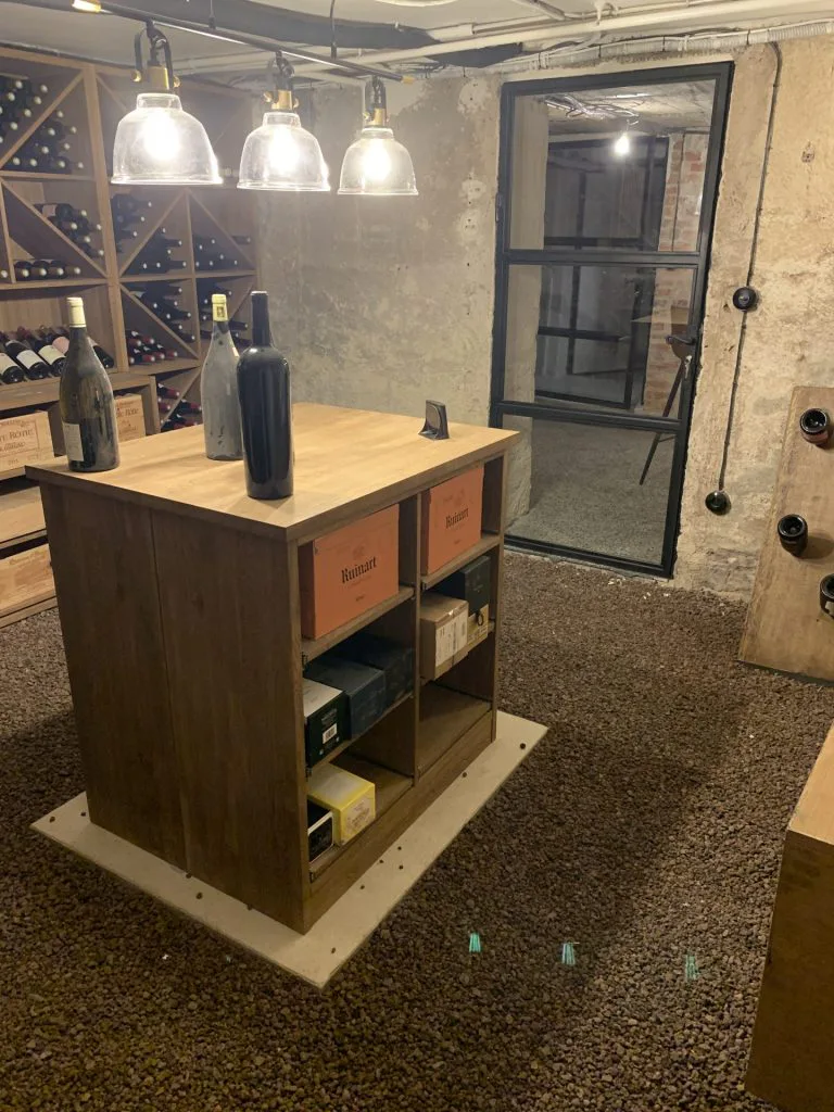 Comptoir de dégustation central sous trois suspensions dans la cave à vin