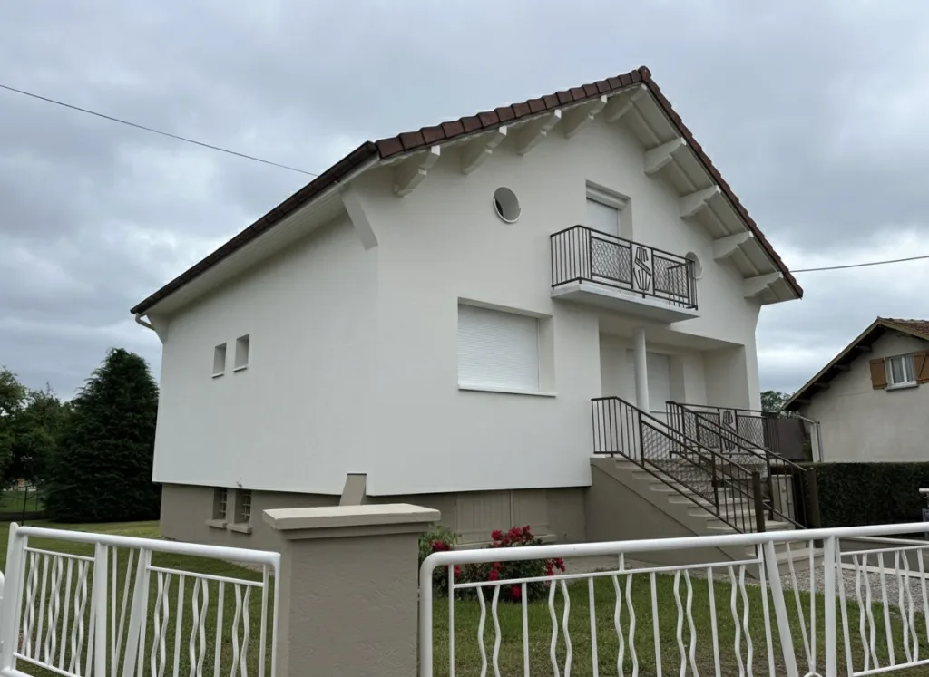Vue de la façade après rénovation, avec enduit blanc et garde-corps métalliques