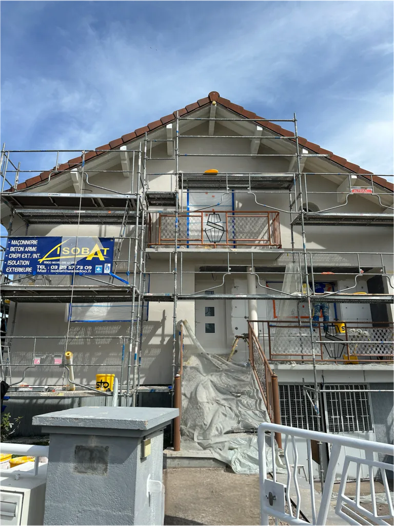 Façade de la maison entourée d’un échafaudage pendant les travaux