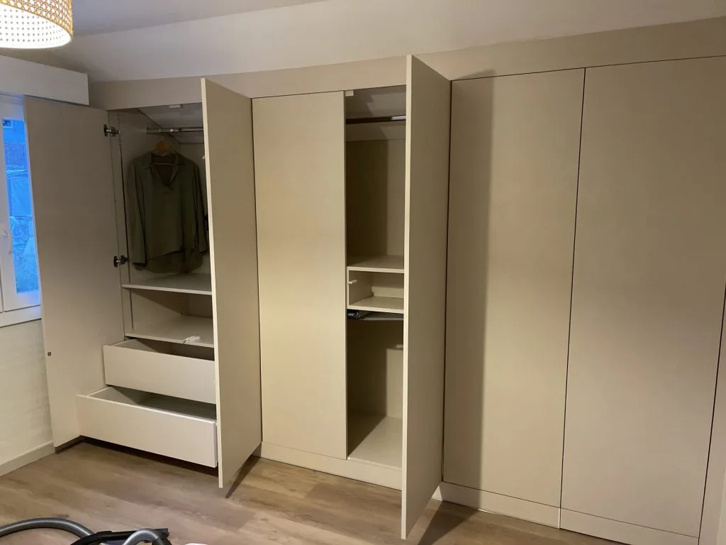 Dressing aménagé avec étagères, penderie et tiroirs dans des rangements beiges