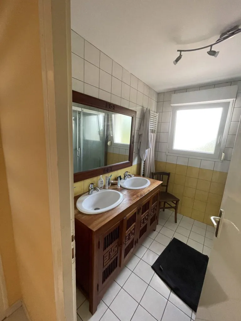 Ancienne salle de bains avec double vasque et carrelage jaune et blanc