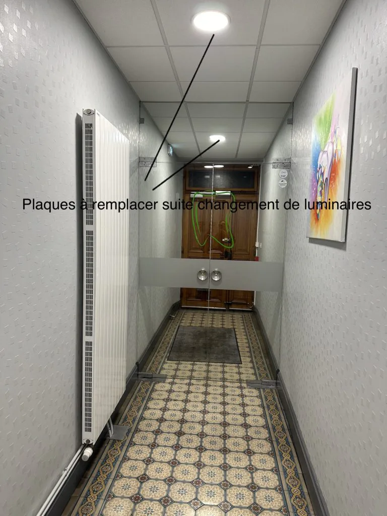 Couloir avant remplacement des luminaires, avec repères sur les dalles du plafond