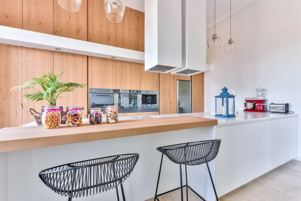 Comptoir de cuisine avec tabourets noirs et rangements en bois sur mesure
