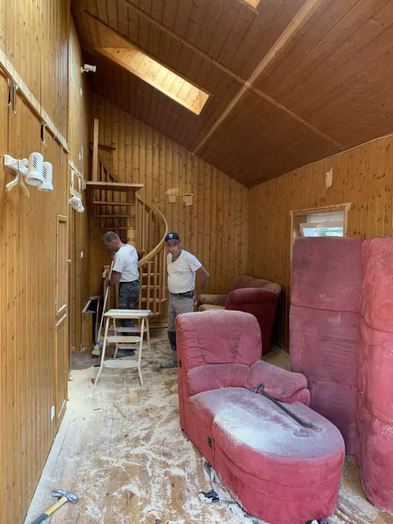 Salon en travaux avec dépose du sol, lambris et mobilier protégé
