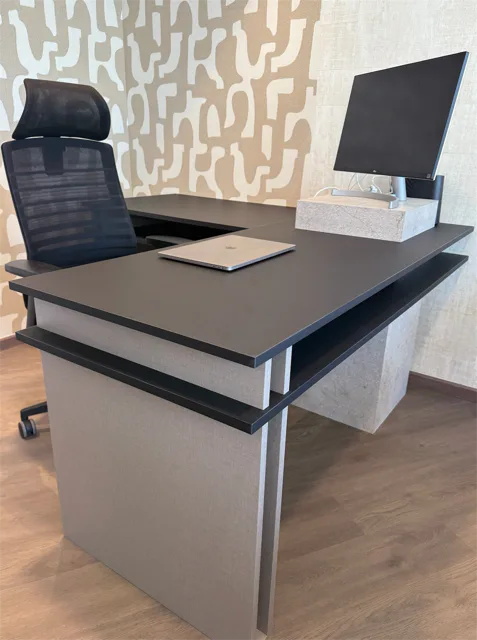 Bureau noir et fauteuil de travail devant les échantillons du showroom