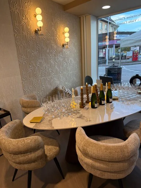 Table du showroom dressée pour un accueil, devant les appliques et la vitrine